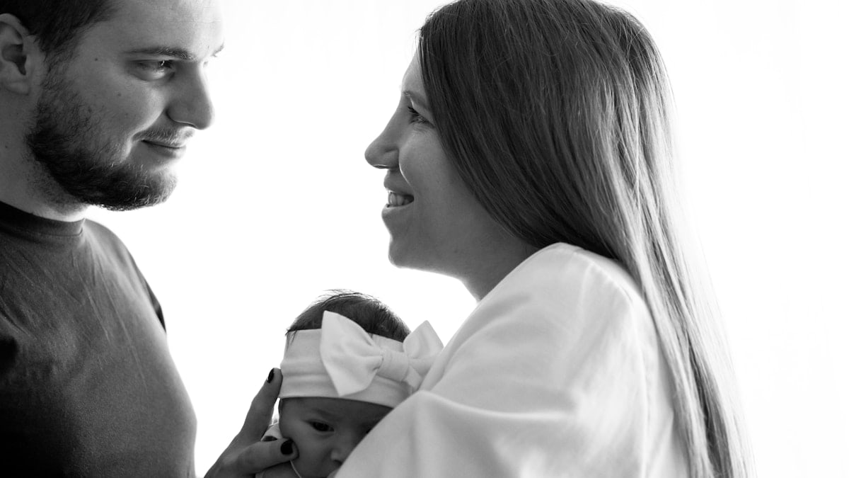 a man and woman holding a baby in their arms